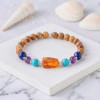 أسورة بفواصل فضة من خشب الكوك بالإضافة لأحجار الفيروز و اللابيس لازولي ( لازورد )  والاماتيست ( جمشت ) وفي المنتصف قطعة كهرمان